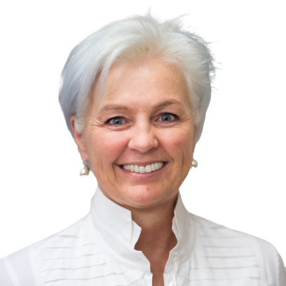 Lächelnde Frau mit kurzen, grauen Haaren und weißer Bluse, auf neutralem Hintergrund.